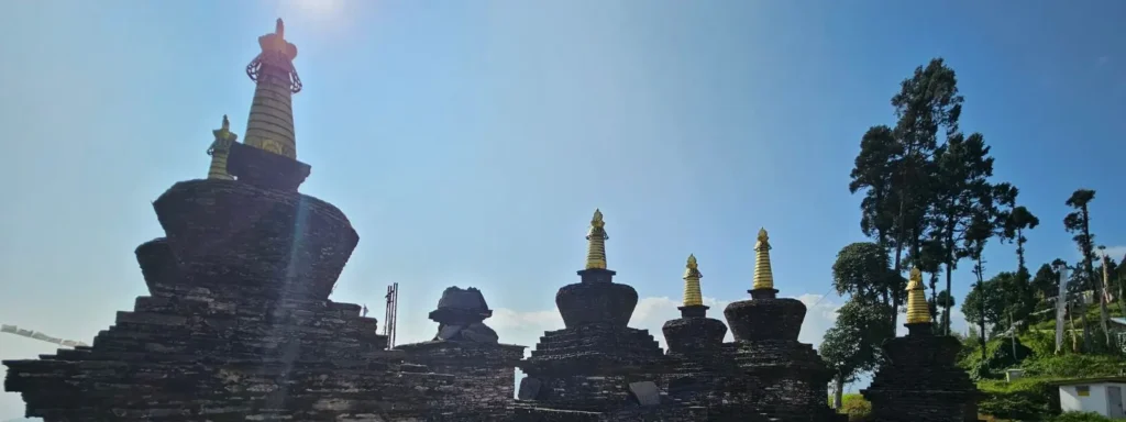 Ancient stone Buddhist stupas at the oldest monastery in West Sikkim under a clear blue sky